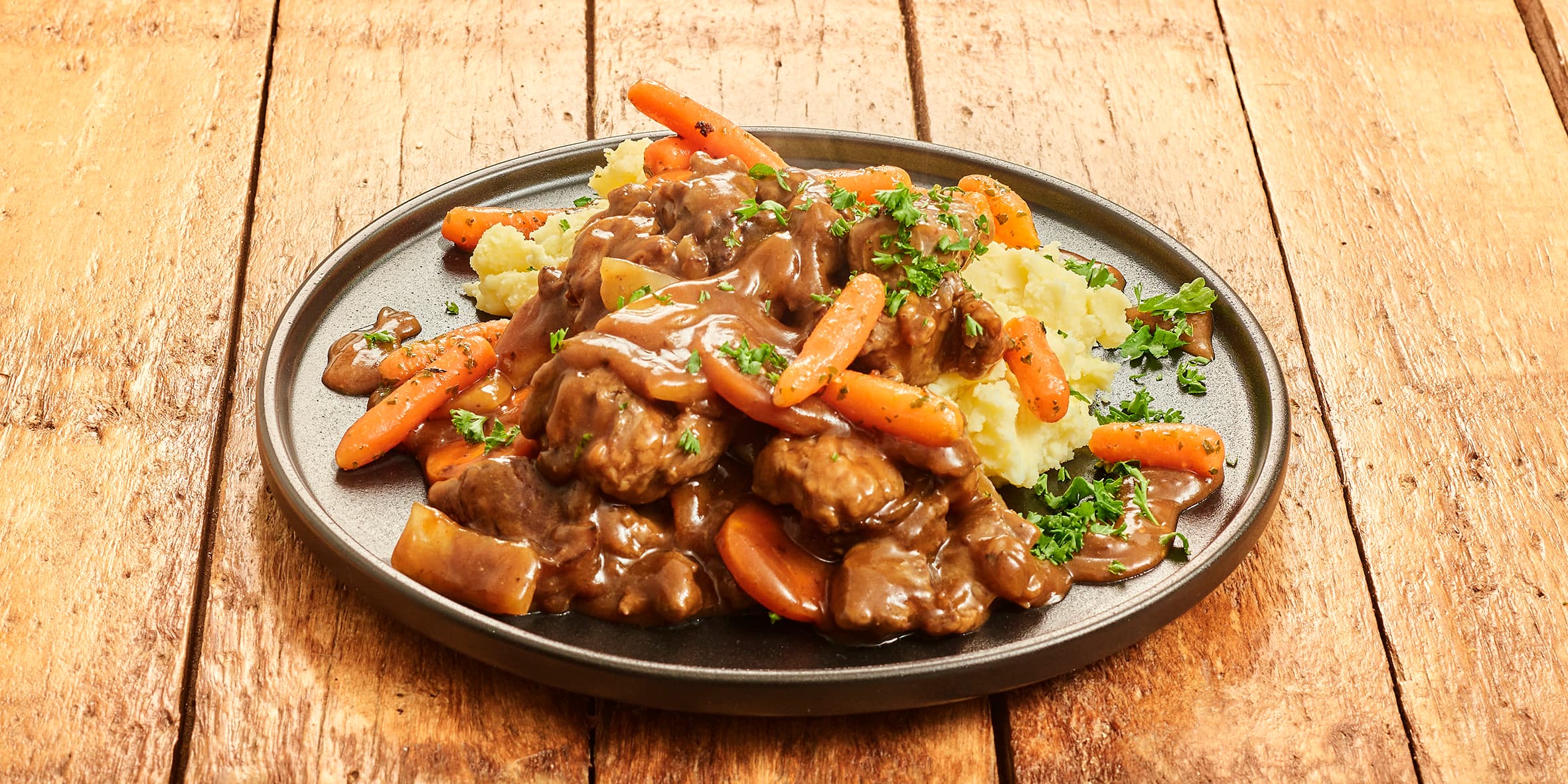 Runderstoofpotje met wortel, ui en aardappelpuree