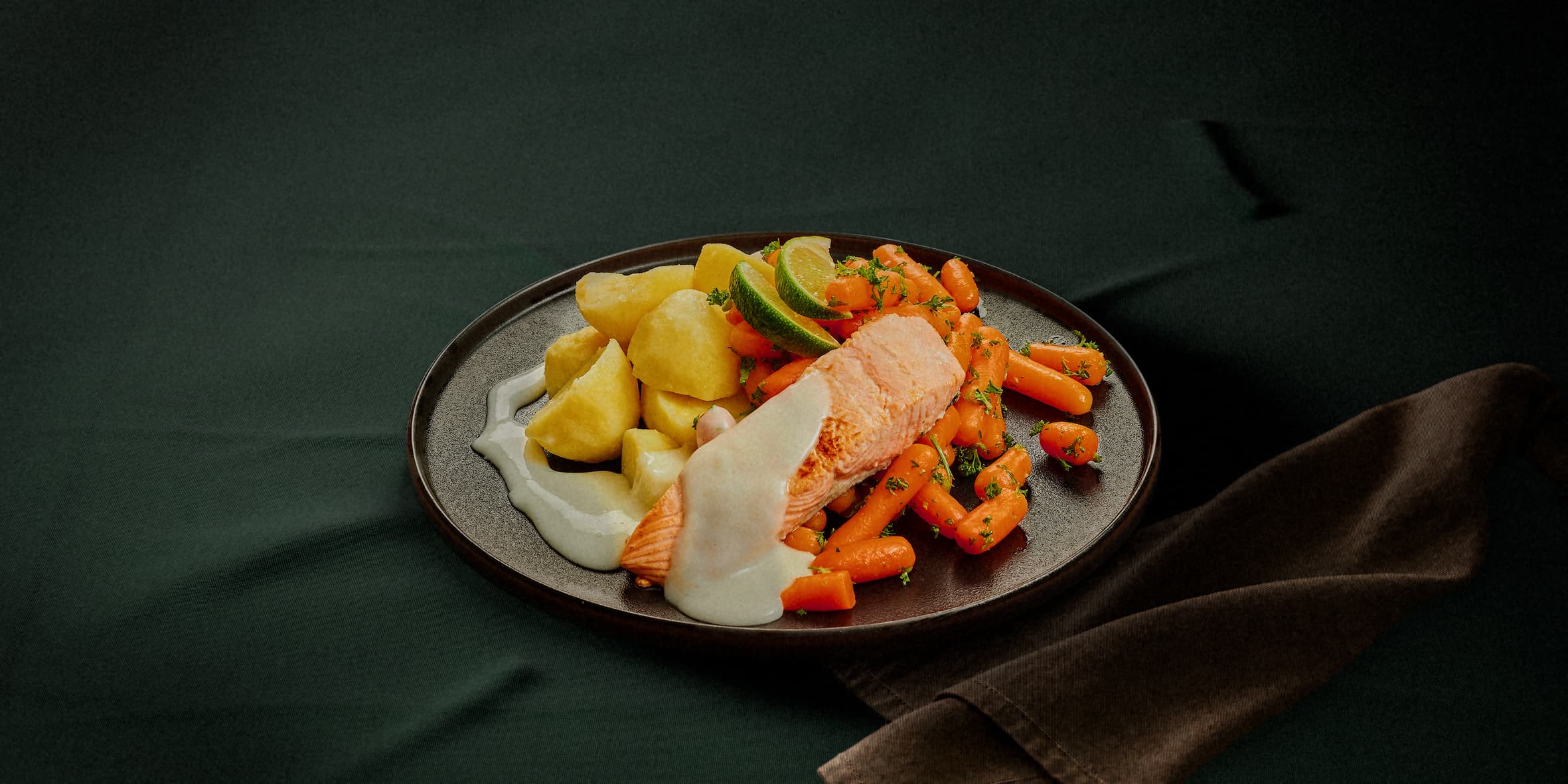 Zalm in botersaus met worteltjes, doperwten en aardappelen